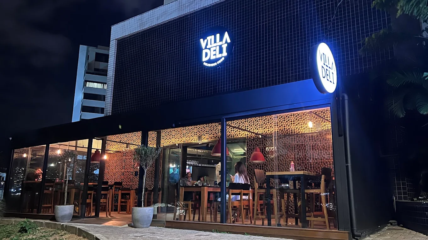 Fachada do Villa Deli à noite, na Vila da Serra